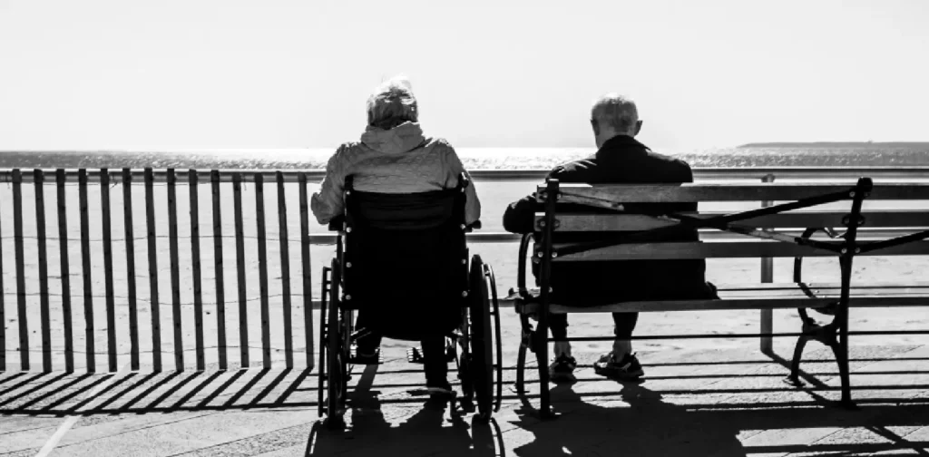 two elderly people sitting with the back facing camera