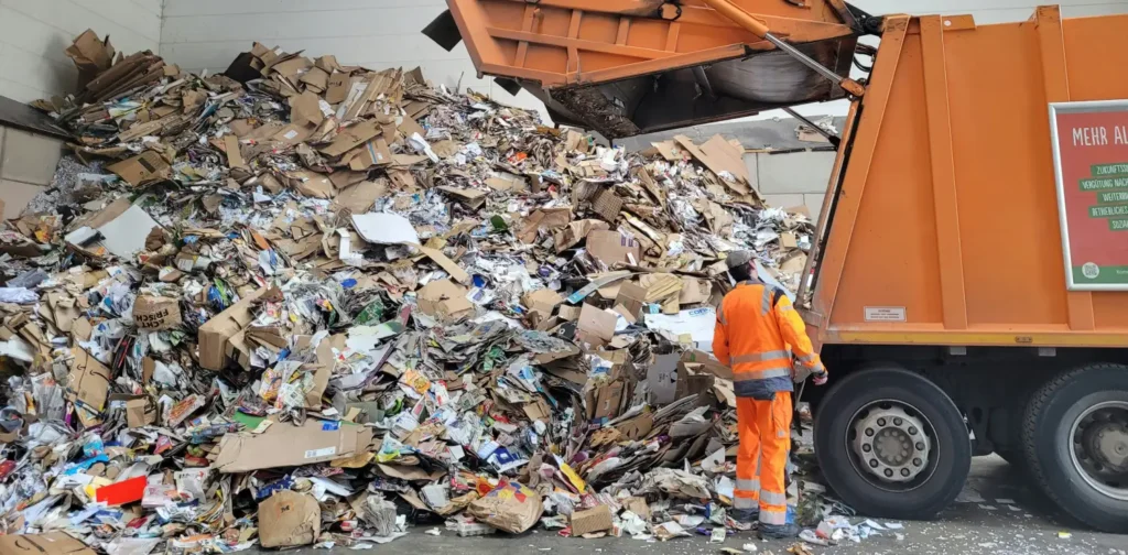 Man standing next to a pile of trash