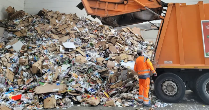 Man standing next to a pile of trash