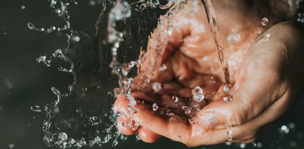 a pair of hands collecting running water