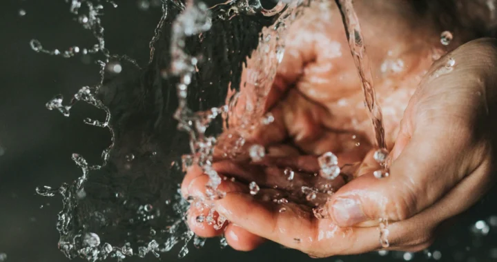 a pair of hands collecting running water