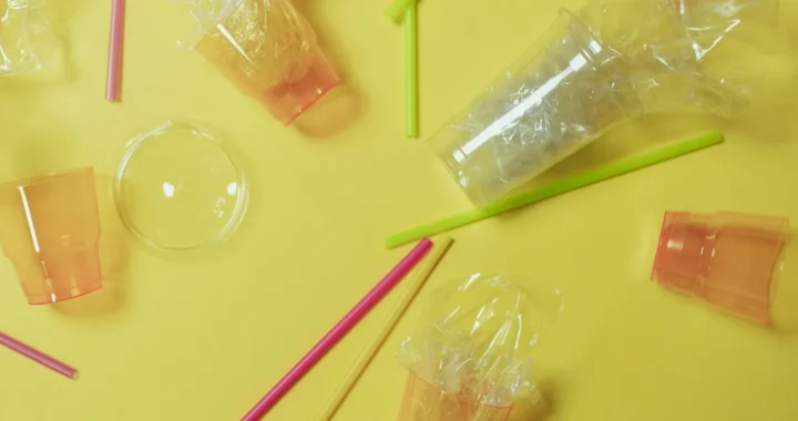 plastic cups and straws on flat background