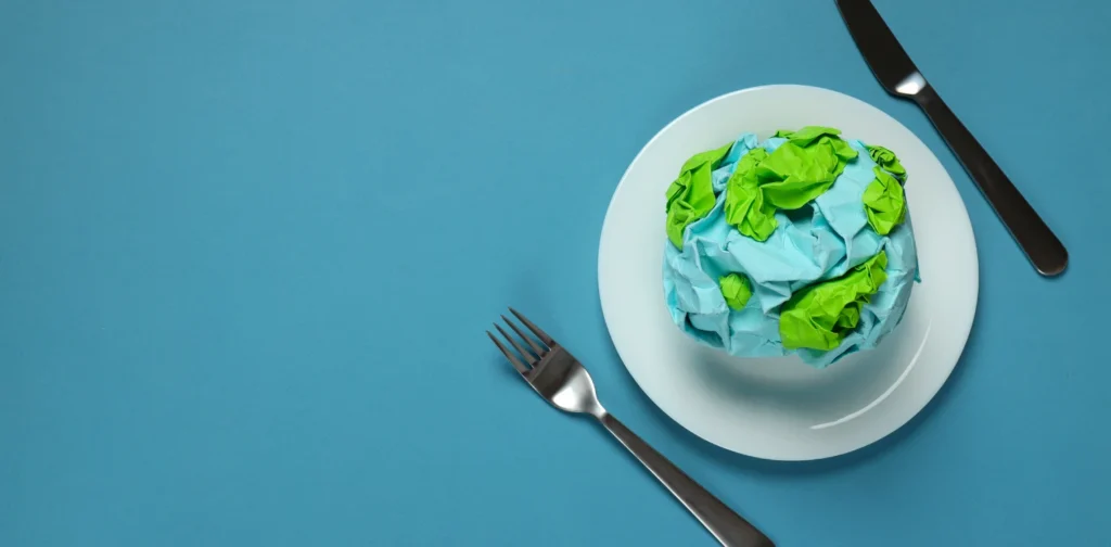 a globe made of paper on a plate with a knife and a fork beside it