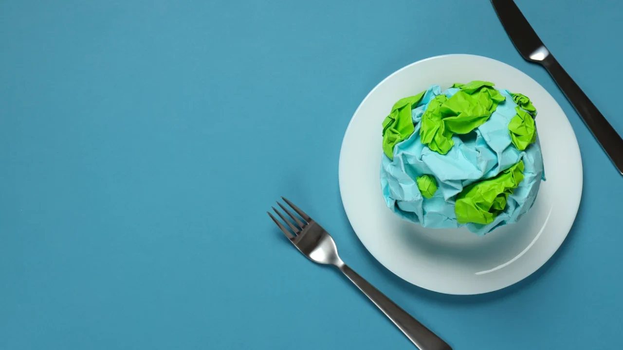 a globe made of paper on a plate with a knife and a fork beside it