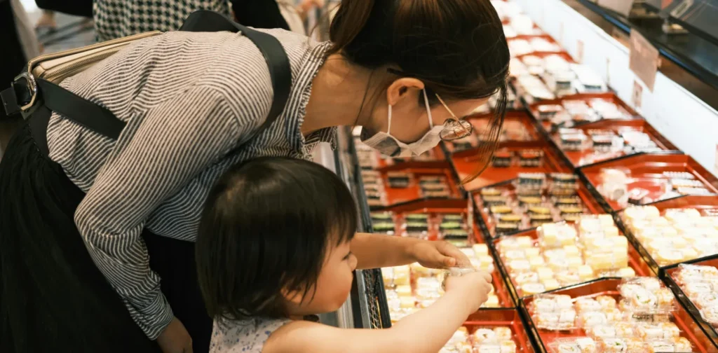 a mother and her daughter shopping for sushi