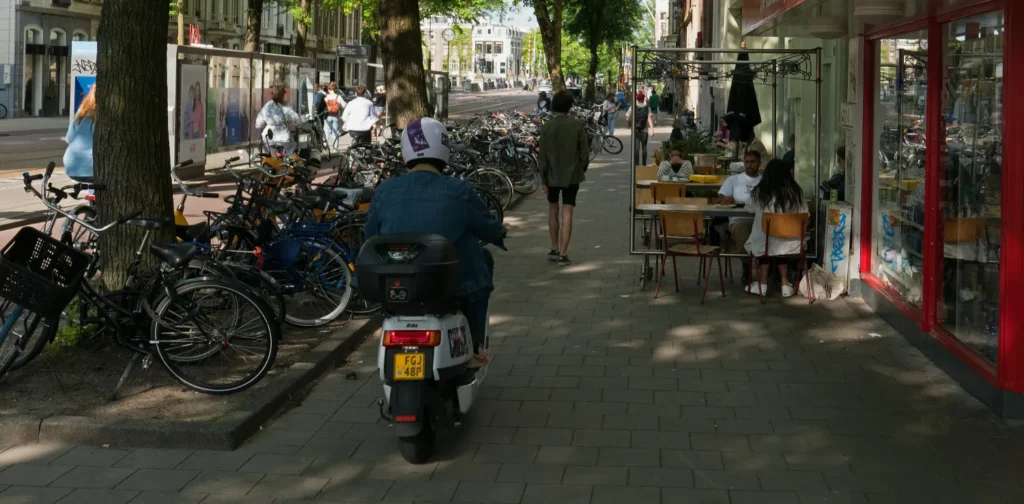 a photo of sidewalks with a man riding a scooter