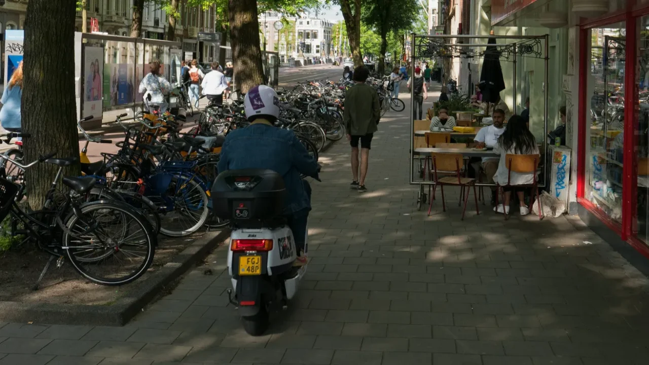 a photo of sidewalks with a man riding a scooter