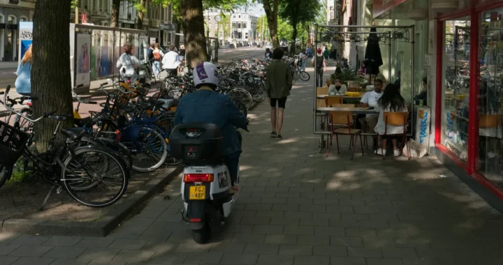 a photo of sidewalks with a man riding a scooter