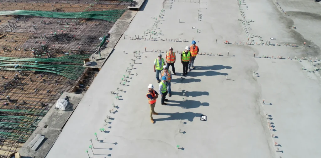 group of people with safety vest and helmet on top of rooftop in construction site