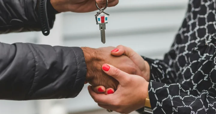 one person handing a house key over to another person