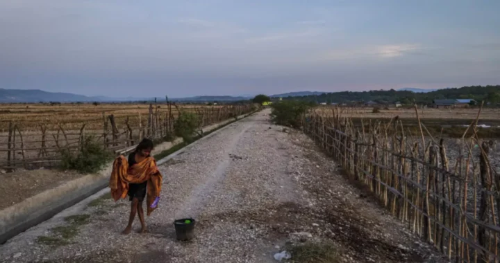 a girl holding a scarf is walking on a deserted road