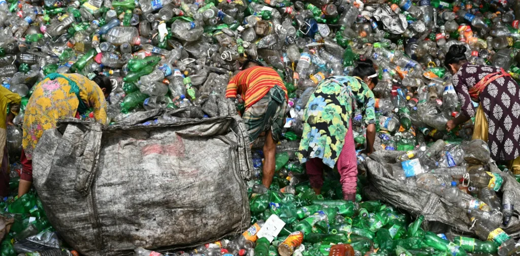 four women sorting out plastic waste in a landfill