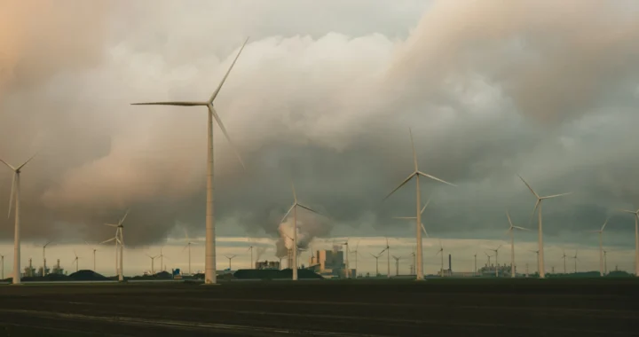 several windmills standing side by side against a cloudy sky