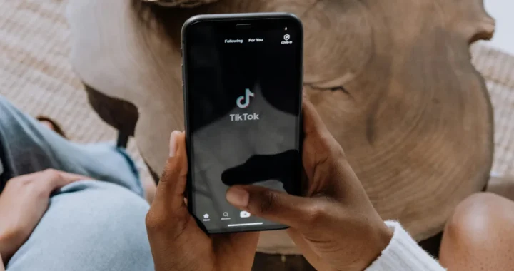 someone holding a phone showing a tiktok homepage