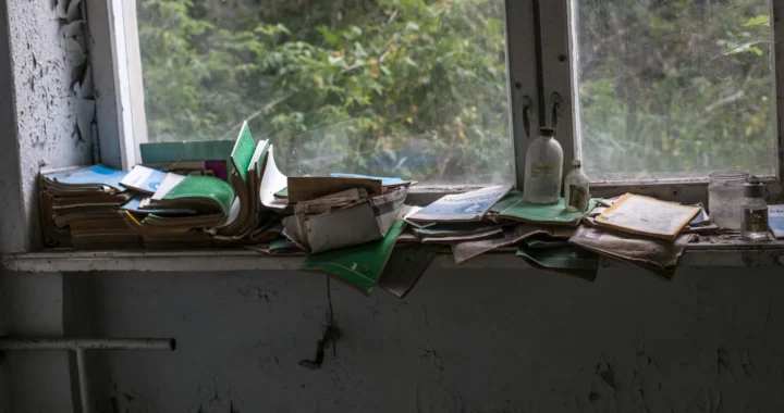 a stack of abandoned books at a windowsill