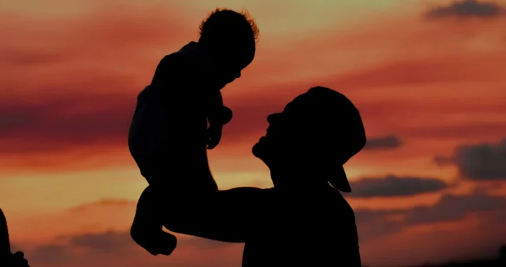 A silhouette of a father carrying his child