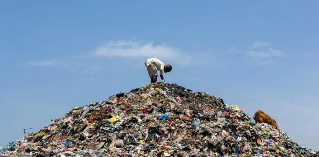 a man on top of a garbage dump