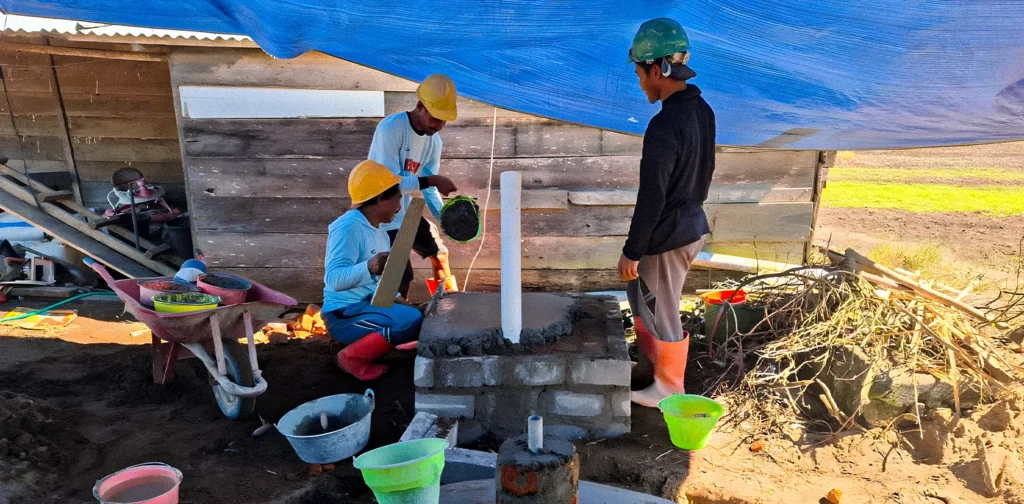 Three men are building a biogas facility.