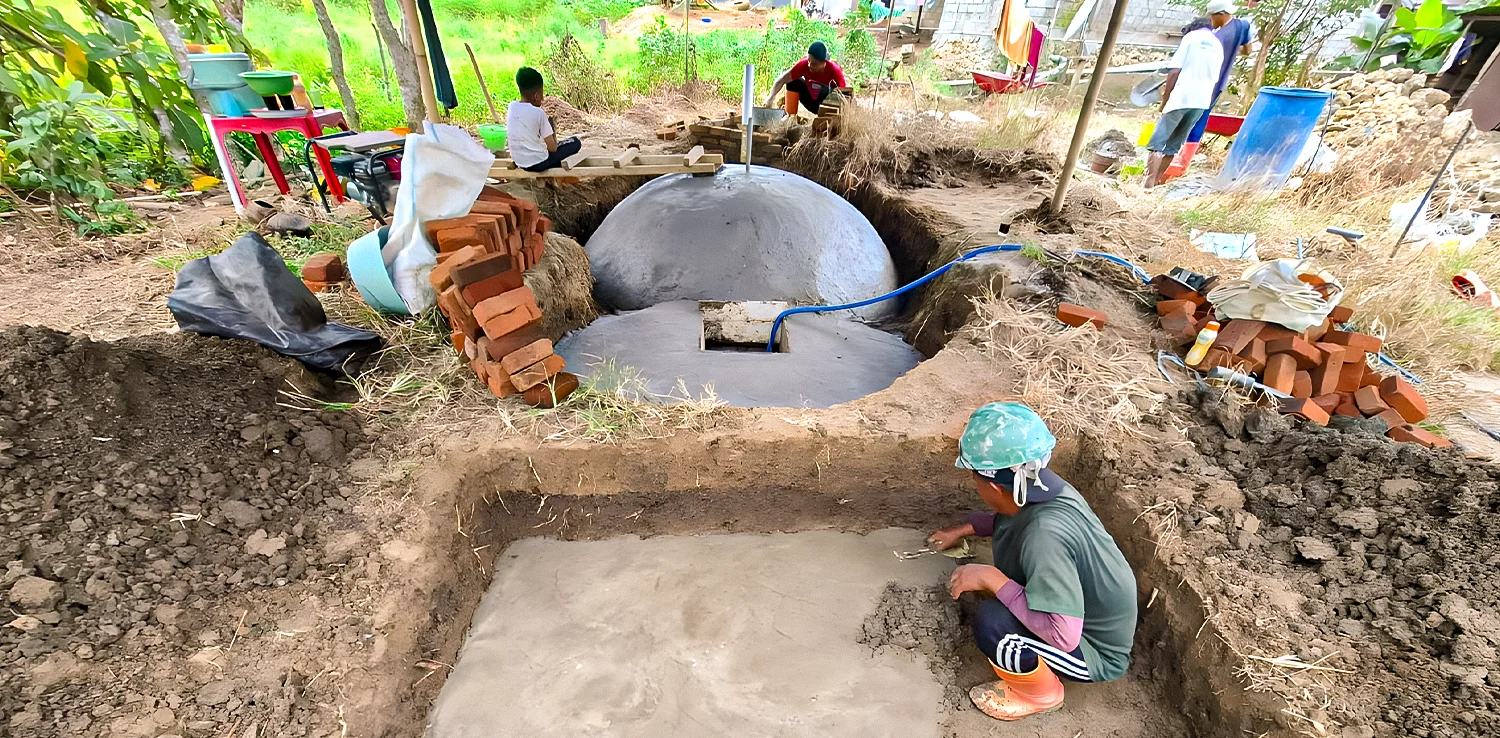 Three men are building a biogas facility.