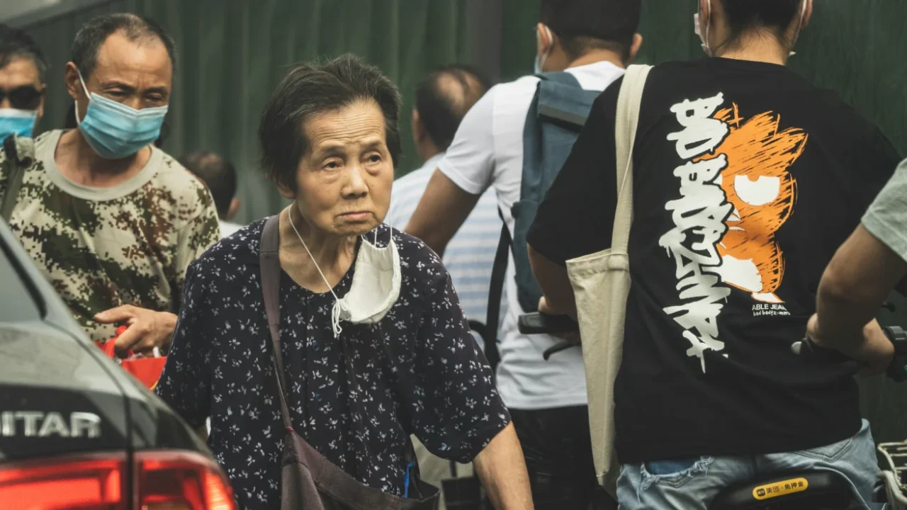 An elderly walk in the crowd.