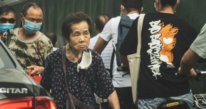 An elderly walk in the crowd.