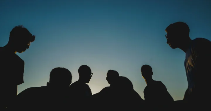 silhouette of people against a blue sky