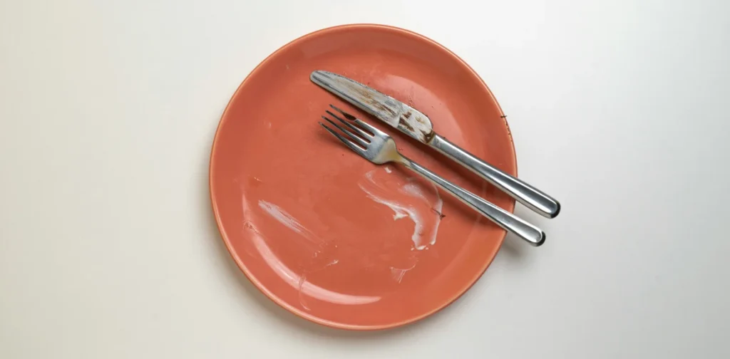 a pink plate with fork and knife