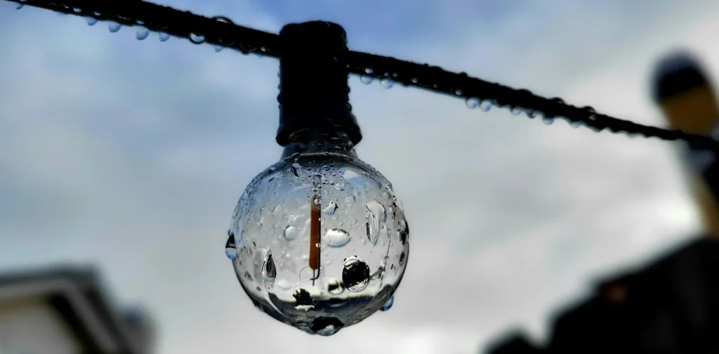 A wet light bulb hanging on a wire