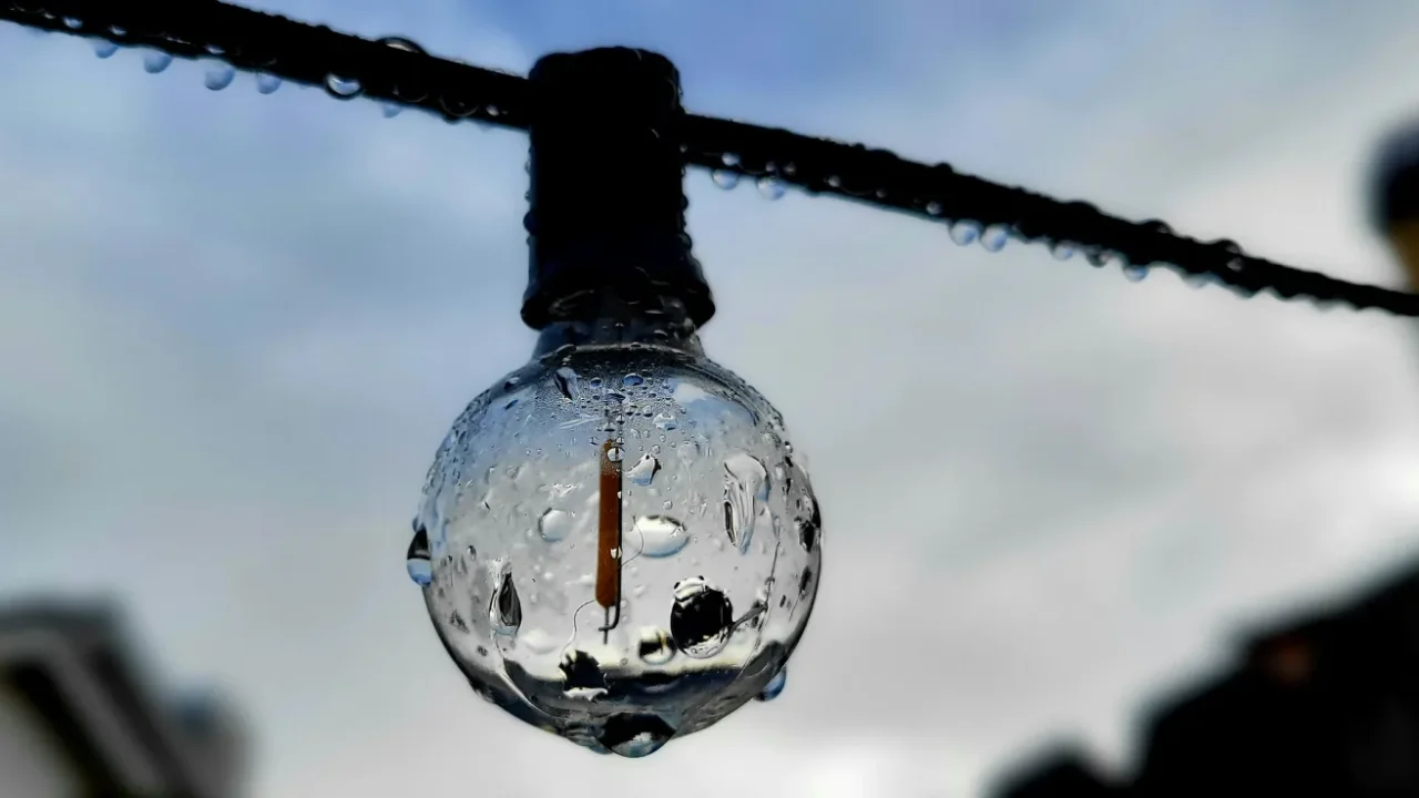 A wet light bulb hanging on a wire