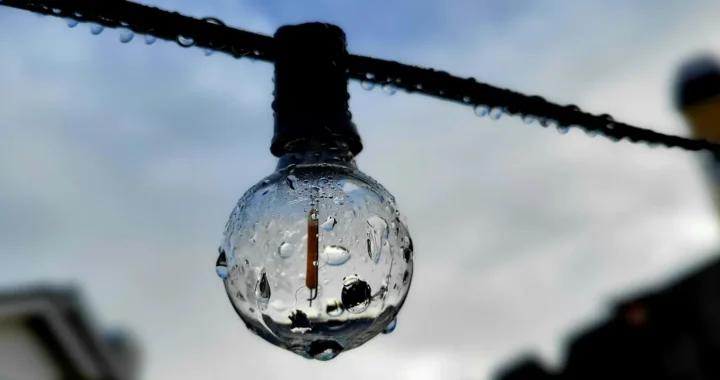 A wet light bulb hanging on a wire