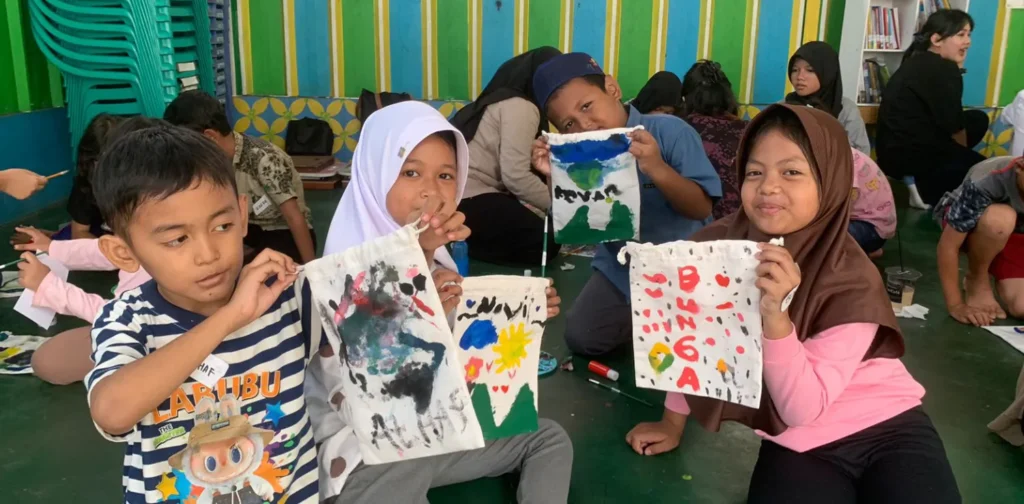 four children at the Inisiasi lantara literacy event posing for the camera with their self-painted book pouches