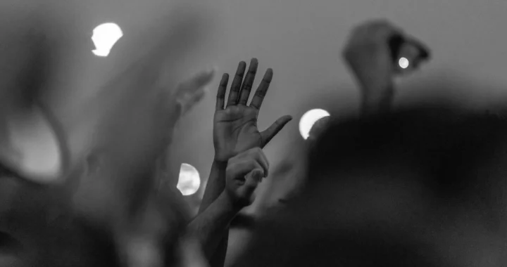 a grayscale photo of a raised hand