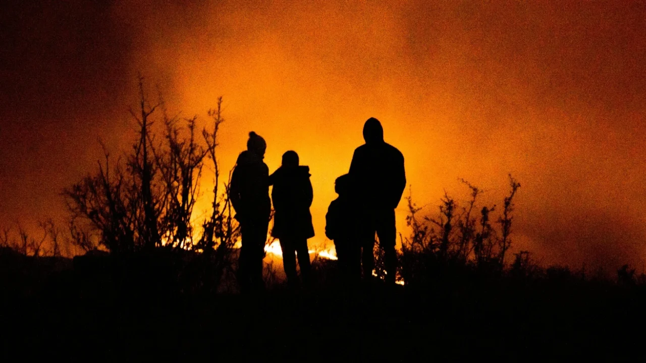 silhouette of family watching wildfire disaster