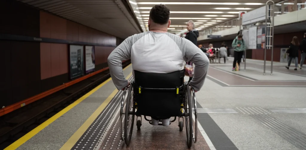 a man with disability pushed wheelchair on train platform