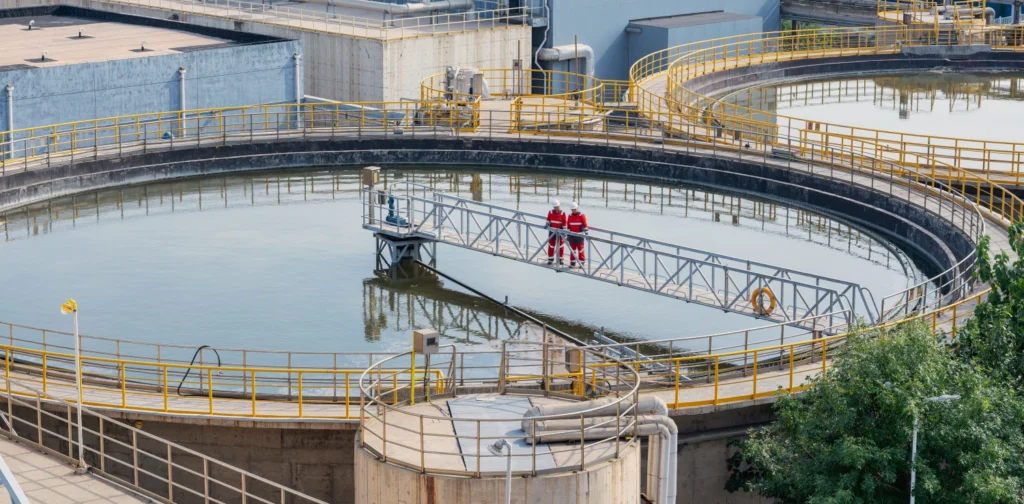 an aerial shot of a water treatment facility with two workers standing in the middle