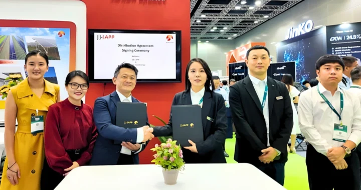 six people standing side by side, with two shaking hands in the middle