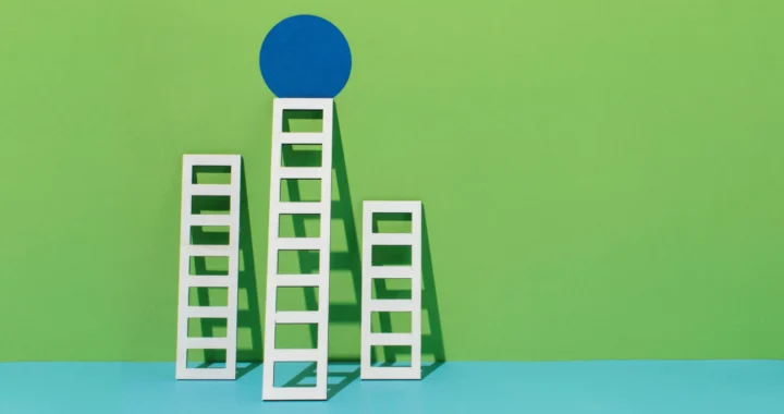 three ladders with different height propped against a wall