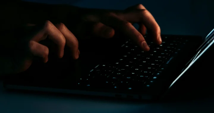 a person typing on their laptop