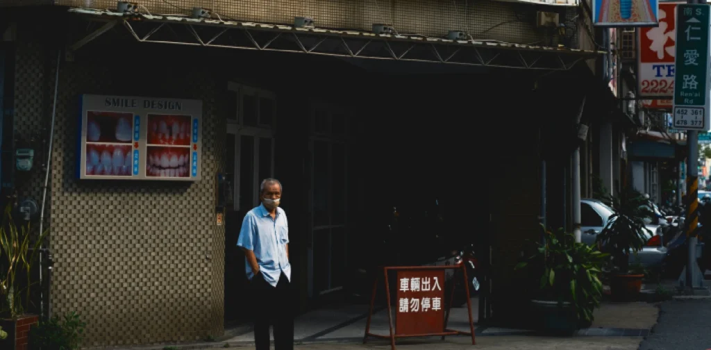 a person wearing a mask in front of a clinic