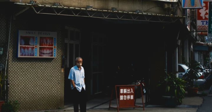 a person wearing a mask in front of a clinic