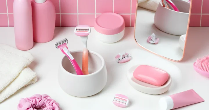 Pink-themed personal care products, including razors, lotion, and soap, arranged neatly on a bathroom counter.