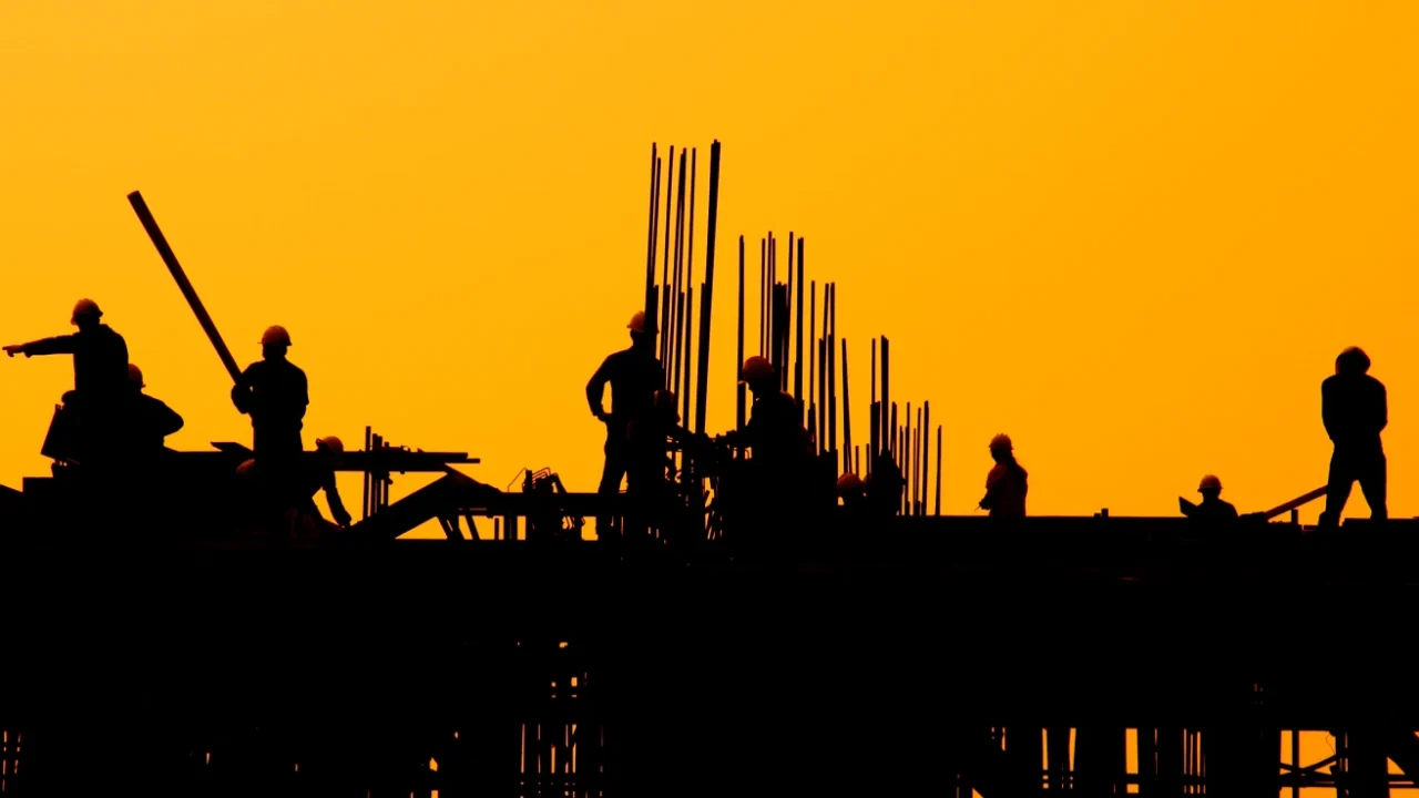 Construction workers at sunset.