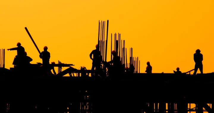 Construction workers at sunset.