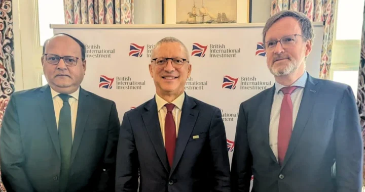 three men in suits smiling at the camera