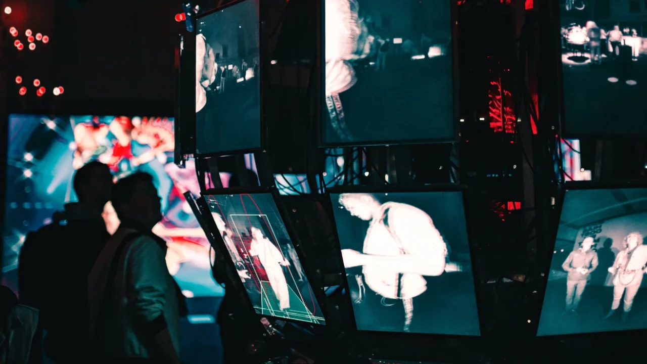 a group of people standing around a display of video screens