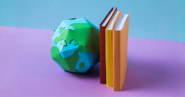 a globe figure propped against books
