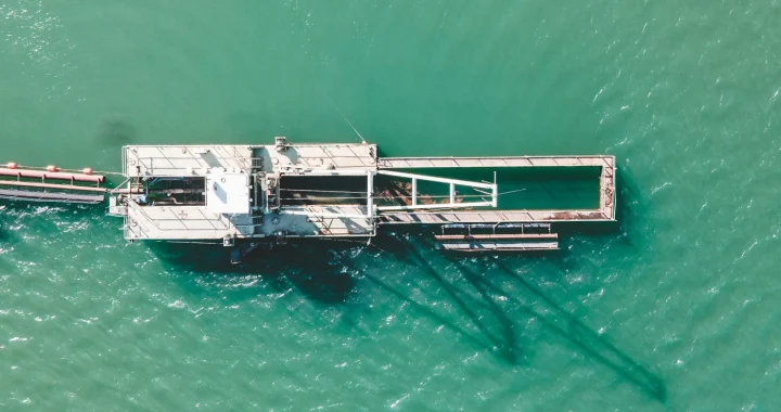 A dock and crane in the middle of an ocean