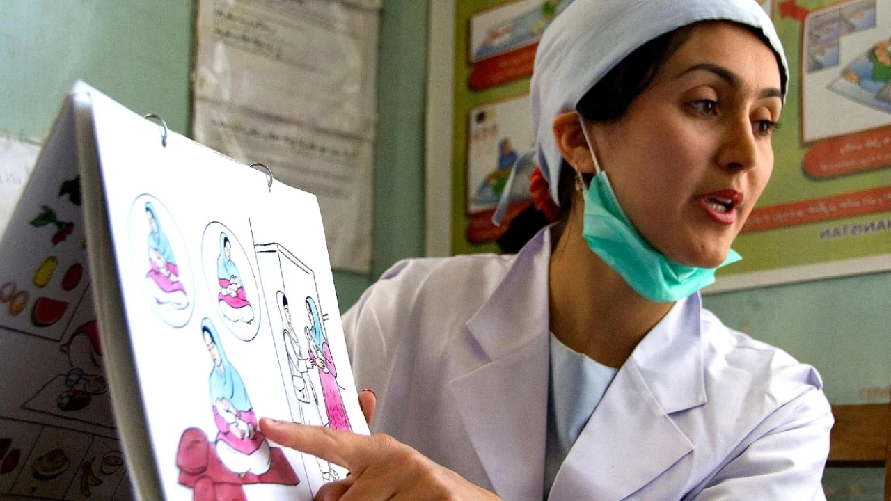 a midwife pointing at illustration of birth process