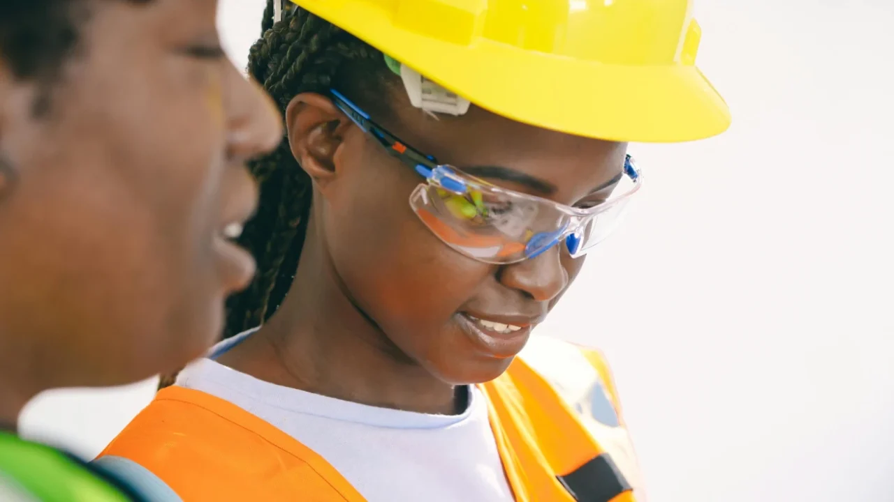 two women in protective gear examining an electricity circuit