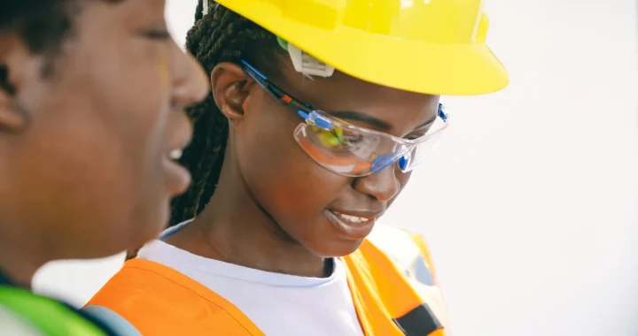 two women in protective gear examining an electricity circuit